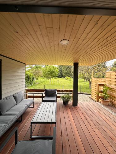 eine Terrasse mit einer Couch und einem Holzdeck in der Unterkunft Ô Ptit Bouleau in Buhl-Lorraine