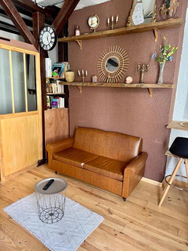 - un canapé dans le salon doté d'une horloge murale dans l'établissement L atypique de bourbonnoux, à Bourges