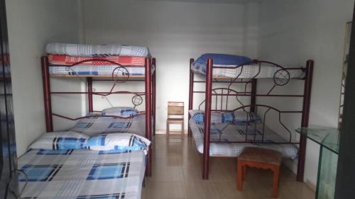 a room with three bunk beds and a chair at Finca Hotel Villa Nieves in Tuluá