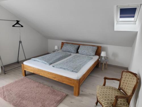 Un dormitorio con una cama y una silla dentro. en Ferienwohnung Down Under am Bodensee, en Uhldingen-Mühlhofen