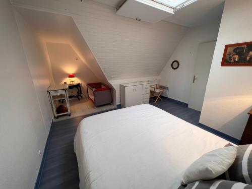 une chambre avec un grand lit blanc dans un grenier dans l'établissement Duplex en plein centre, 3min plage, à Deauville