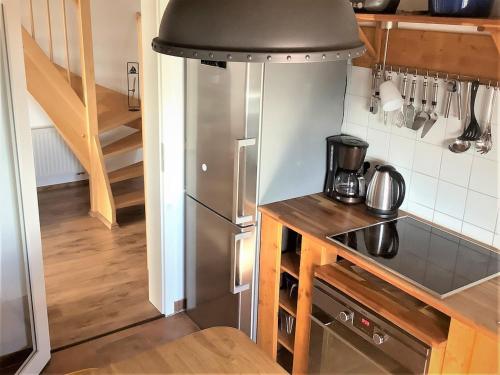 a kitchen with a stainless steel refrigerator and a staircase at Ruhige Maisonette-Wohnung mit Blick über Röbel "Kleines Himmelreich" in Röbel