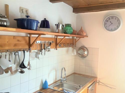 a kitchen with a sink and a clock on the wall at Ruhige Maisonette-Wohnung mit Blick über Röbel "Kleines Himmelreich" in Röbel