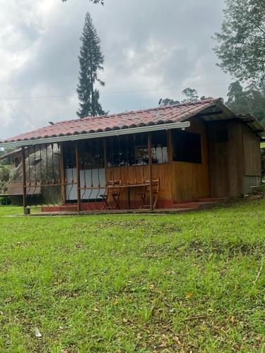 ein kleines Haus mit einem Grasfeld davor in der Unterkunft Cabañita en el Parque Natural Ecocenter in Santandercito