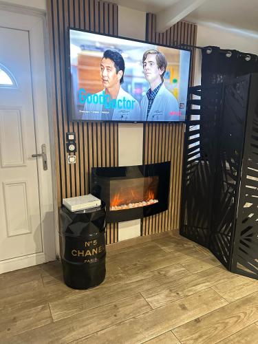 un salon avec une cheminée et une télévision dans l'établissement AppartSpa, à Tremblay-en-France