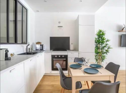 - une cuisine blanche avec une table et des chaises en bois dans l'établissement Cosy azur au coeur du vieux port, à Marseille