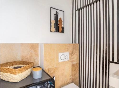 - une salle de bains avec des toilettes et un panier sur un comptoir dans l'établissement Cosy azur au coeur du vieux port, à Marseille