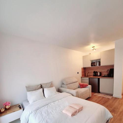 une chambre avec un lit et un canapé dans l'établissement Studio FANTASIA with private car-park - 15min to Disneyland by city bus Number 2233, à Montévrain