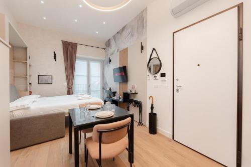 a hotel room with a bed and a table and a bed and a room at Casa Giusy Esclusiva Suite Molinette Torino in Turin