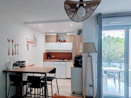 une cuisine avec une table et des chaises ainsi qu'un ventilateur de plafond dans l'établissement F2 garage box WiFi terasse clim Gare Fac Eco Richter, à Montpellier