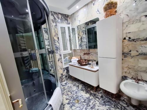 a bathroom with a shower and a sink at L'Orchidée - Suites de Luxe avec Piscine Chauffée et Vue sur le Lac de Tunis in Tunis