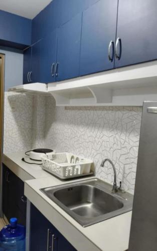 a kitchen with a sink and blue cabinets at Standard Room at 8 Spatial by Forever-mc Condotel 8335 in Davao City