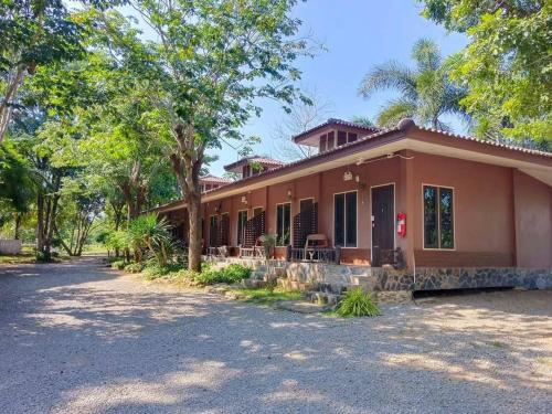 a house with a driveway in front of it at Baan Varintorn Suanphueng in Suan Phung