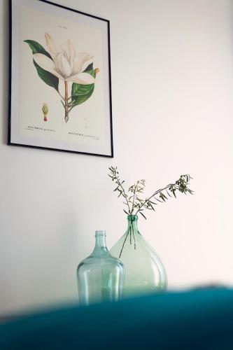 a glass vase with flowers in it next to a picture at L'abri de Saint-Germain, between lake and mountains in Talloires