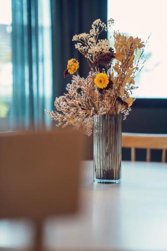 a vase filled with flowers sitting on a table at L'abri de Saint-Germain, between lake and mountains in Talloires