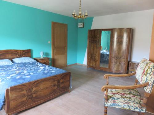 a bedroom with a bed and a chair and a mirror at Gîte Marie des Côtes in Hannonville-sous-les-Côtes