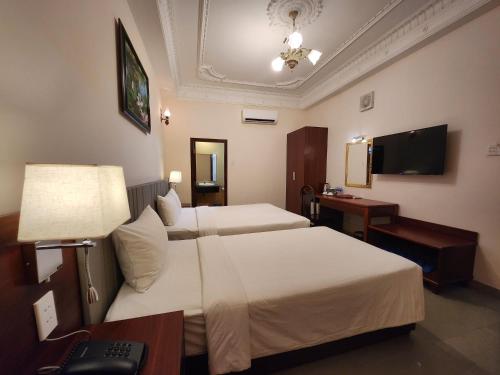 Postel nebo postele na pokoji v ubytování Bon Ami Hotel - Thiên Xuân Hotel