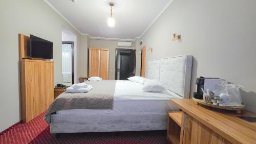 a bedroom with a large bed and a flat screen tv at Pensiunea Bucura in Călimăneşti
