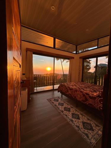 a bedroom with a bed and a view of the sunset at Athila Ecolove in Monteverde Costa Rica
