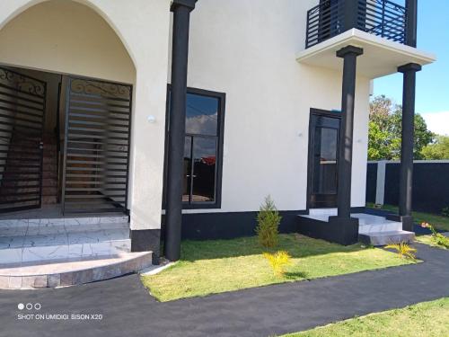 a white house with black doors and windows at Paradise Palm Villa in Barnes Green