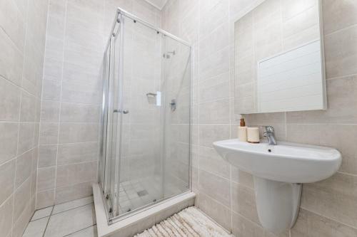 a white bathroom with a shower and a sink at Exquisite Lavish-Luxury Apartment in Sandton