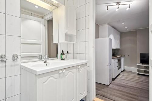a white kitchen with a sink and a refrigerator at Apt 500 m to Bryggen - Perfect location in Bergen