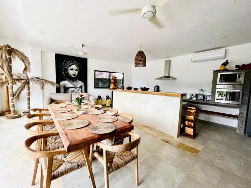 a kitchen and living room with a wooden table and chairs at Villa Aora Bingin Large 4 Bedroom Villa in Uluwatu
