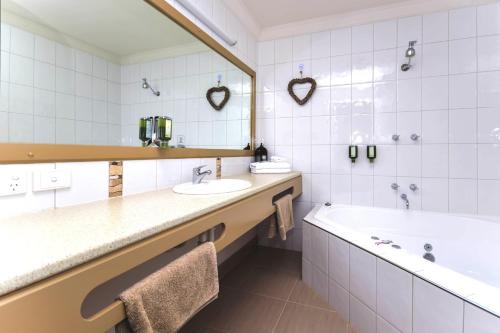 a bathroom with a tub and a sink and a bath tub at River Country Inn in Moama