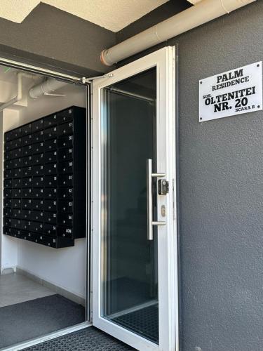 a sliding glass door with a sign on the wall at Studio Palm in Popeşti-Leordeni