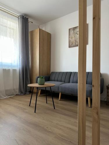 a living room with a blue couch and a table at Studio Palm in Popeşti-Leordeni