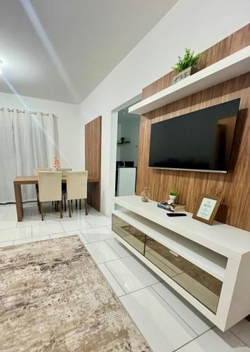 a living room with a large television and a table at Apê Conforto in Brusque