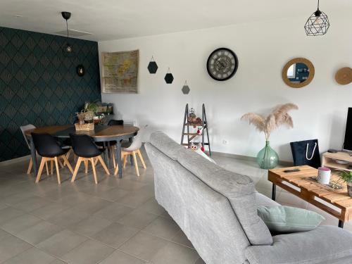 un salon avec un canapé et une table dans l'établissement Le coin des piplettes, à Le Dézert