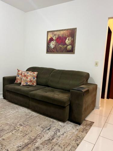 a brown leather couch sitting in a living room at Apê Conforto in Brusque