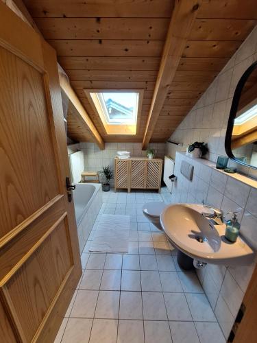 a bathroom with a sink and a bath tub at Ferienwohnung am Bach in Bischofswiesen