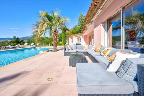 un patio avec des canapés à côté d'une piscine dans l'établissement Charmante villa de 6 chambres, à Mouans-Sartoux