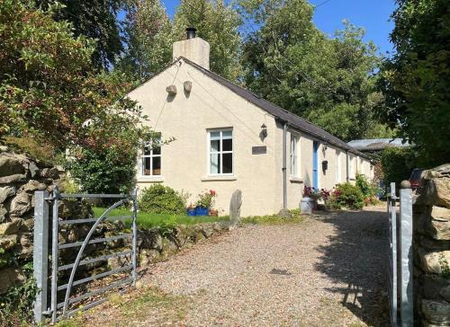 a white house with a fence in front of it at Curragh-Ard Cottage in Newcastle