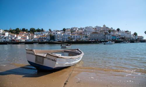 a boat sitting on the shore of a beach at Casa Kantara in Ferragudo