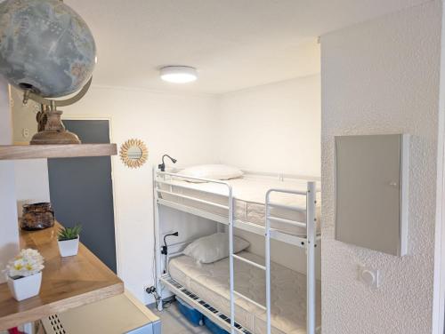 Cette chambre comprend des lits superposés et un miroir. dans l'établissement Studio Cabine 4 personnes Cap d'Adge, au Cap d'Agde
