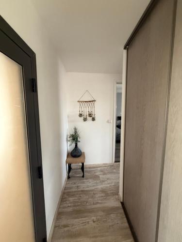 a hallway with a table and a chandelier at Escale au Calme in Le Pouzin