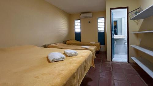 a room with three beds with towels on them at Casa do Mineiro Jacumã RN in Ceará-Mirim