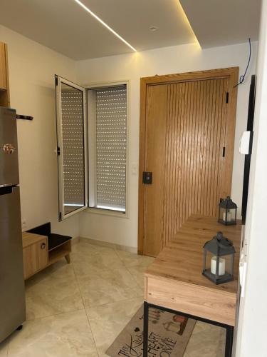 a kitchen with a wooden table and a refrigerator at DARZAYNAH in Monastir