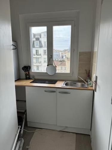 une cuisine avec un évier et une fenêtre dans l'établissement Cozy Room Nearby Champs Elysées 12, à Paris