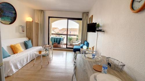 un salon avec un canapé et une table dans l'établissement Appartement dans résidence piscine chauffée, au Barcarès