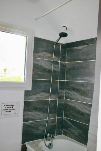 La salle de bains est pourvue d'une douche et d'un mur vert. dans l'établissement Maison individuelle 6 personnes, à Luz-Saint-Sauveur