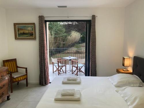 a bedroom with a bed and a balcony with a table and chairs at Loumar in Saint-Tropez