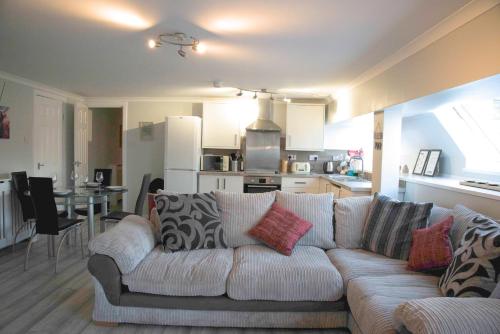 a living room with a white couch and a kitchen at The Stables - Fabulous stylish flat in Merchant City & Free Secure Parking in Glasgow