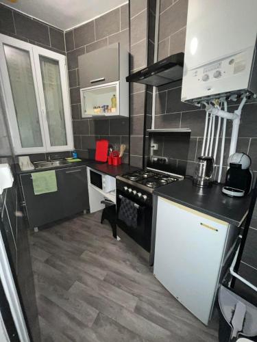 Il comprend une petite cuisine équipée d'une cuisinière et d'un évier. dans l'établissement COZY apartment close to Paris, à Saint-Ouen