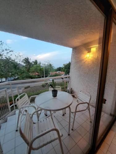 a patio with a table and chairs on a balcony at Apartamento Terrazas de Guacuco in Las Piedras