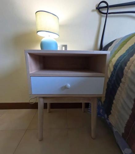 a nightstand with a lamp on it next to a bed at Little Home in Pignone