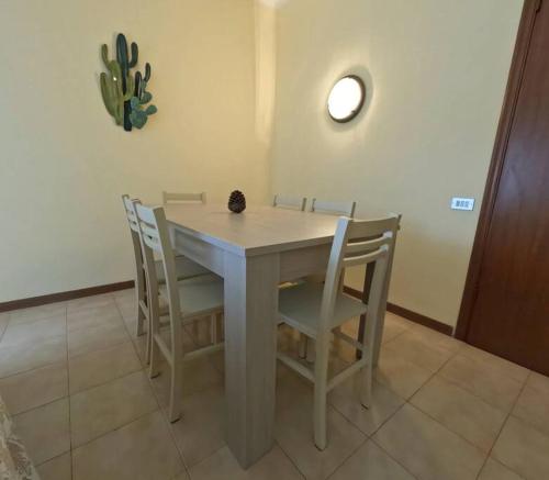 a dining room table with chairs and a cactus on the wall at Little Home in Pignone